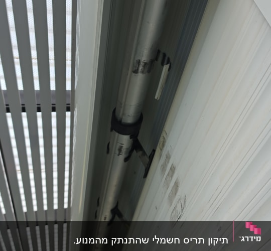 מבט אל תוך ארגז תריס גלילה פתוח ומנגנון הגלילה